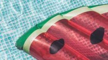 Eine Luftmatratze in Form einer Wassermelone treibt auf der Oberfläche eines Schwimmbeckens